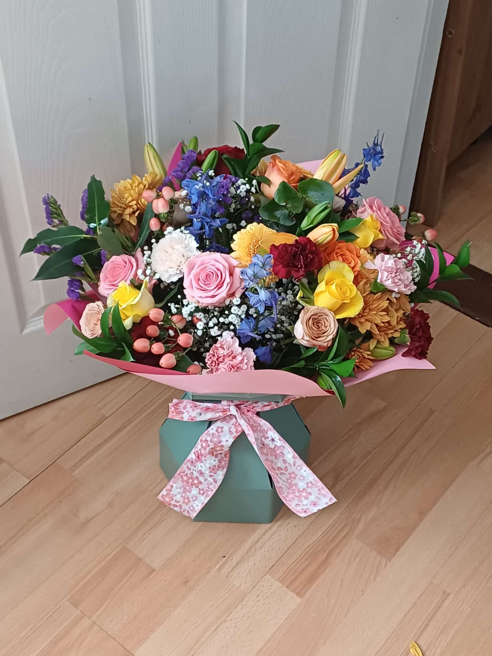 A vibrant bouquet of pink and yellow roses, purple flowers and mixed foliage, handcrafted by Letty’s Flowers